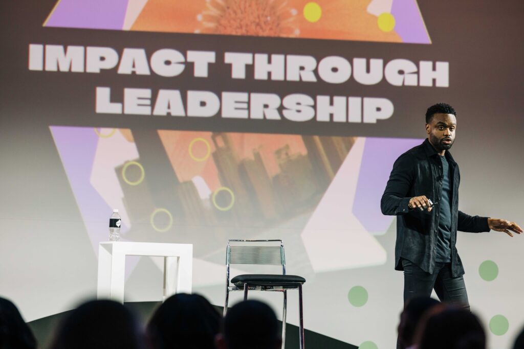 man presenting on stage at conference